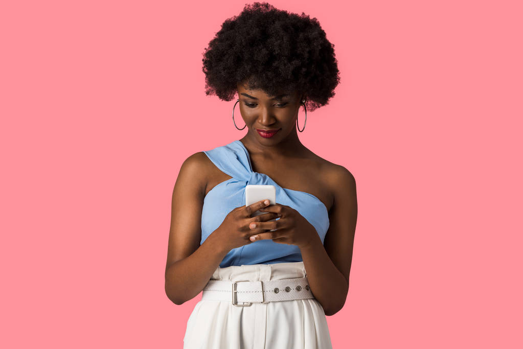 chica afroamericana bonita usando teléfono inteligente aislado en rosa
  - Foto, Imagen