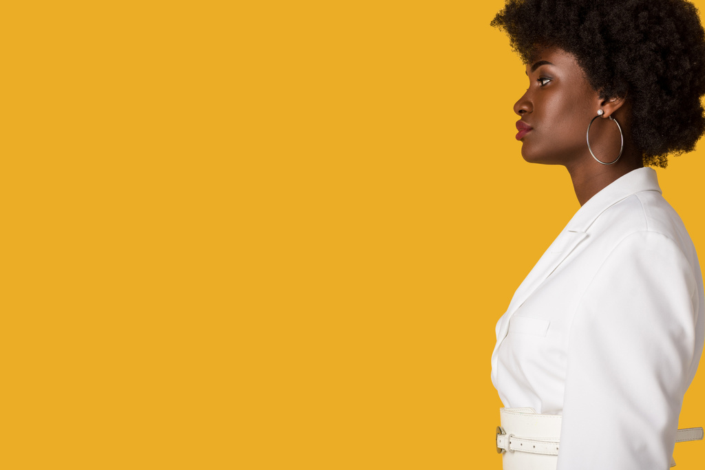 オレンジ色に孤立した魅力的なアフリカ系アメリカ人女性の側面図  - 写真・画像