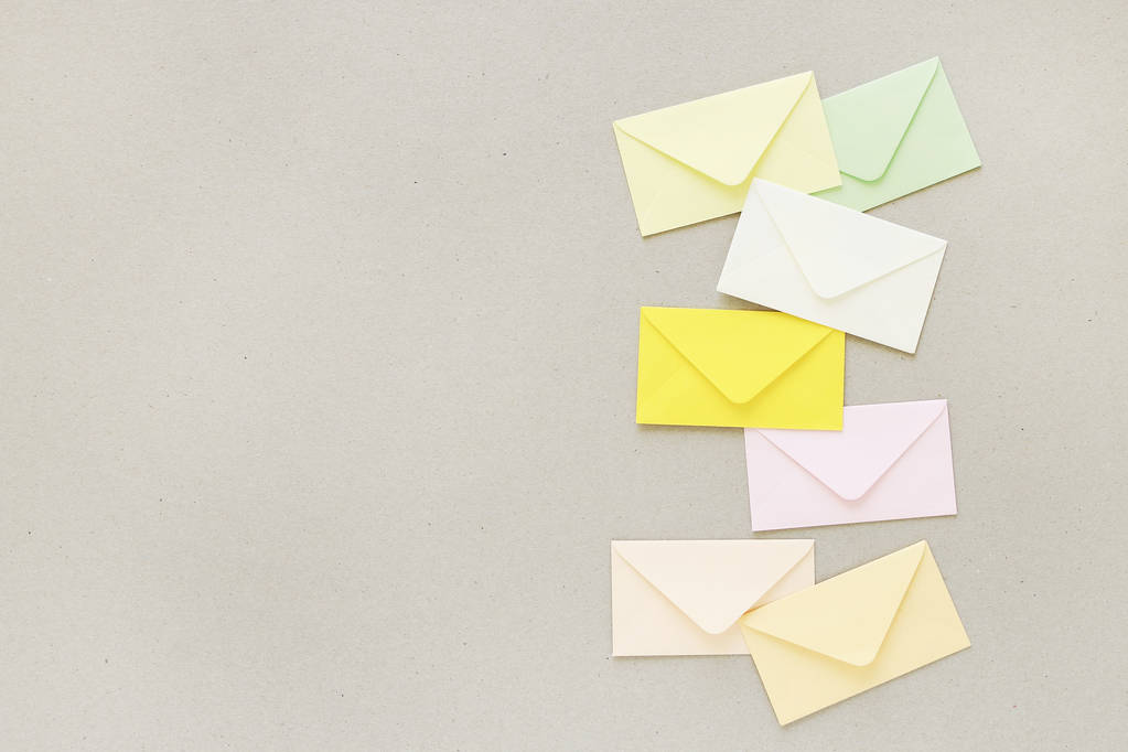 Envelopes coloridos sobre fundo de papel cinza, espaço de cópia
. - Foto, Imagem