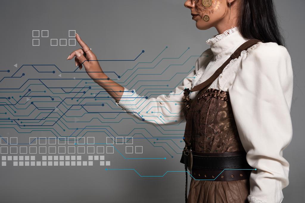 cropped view of steampunk young woman pointing with finger at data illustration - 写真・画像