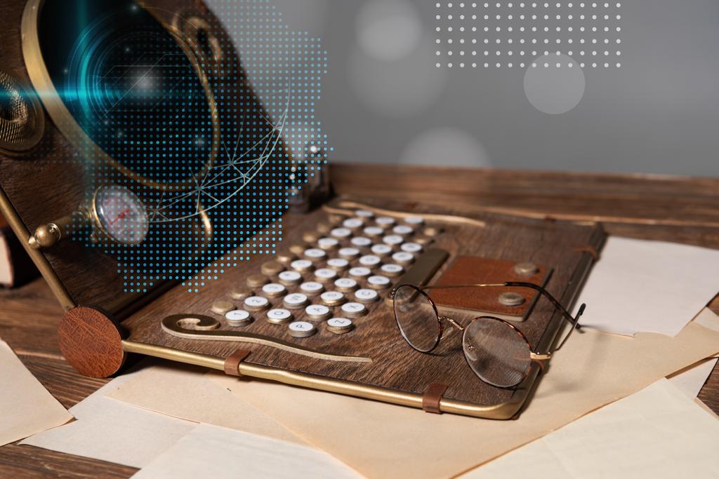 steampunk laptop with data illustration, glasses and documents on wooden table isolated on grey - Photo, Image