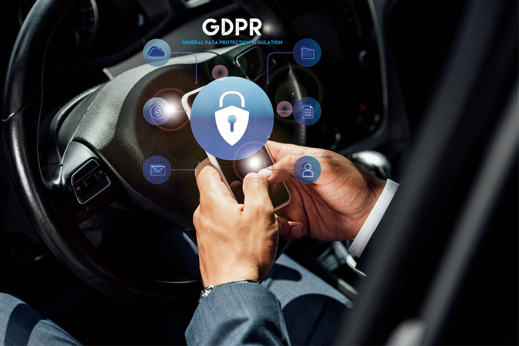 partial view of african american businessman in suit using smartphone with gdpr illustration in car at sunny day - Photo, Image