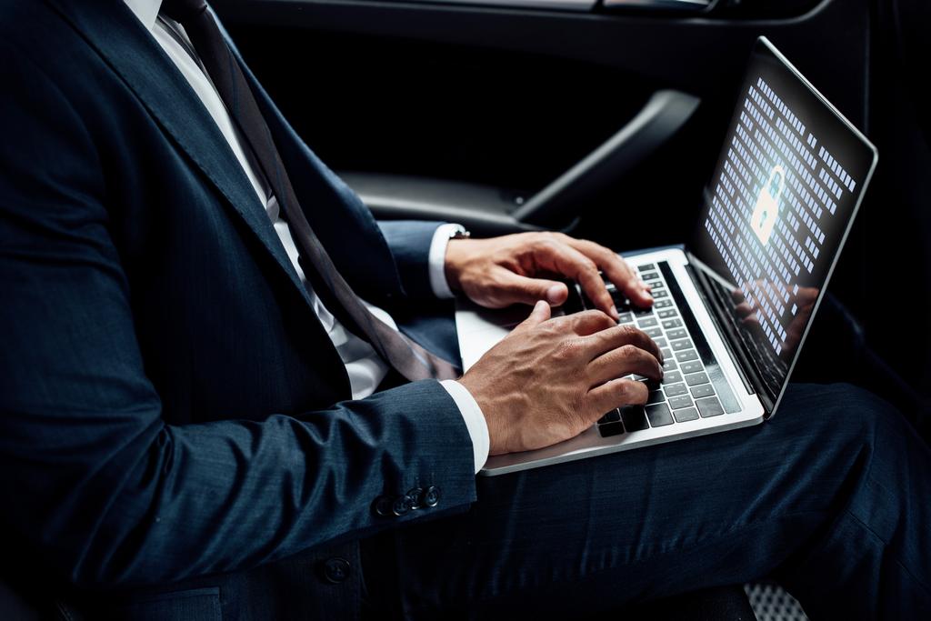 vista parcial del hombre de negocios afroamericano utilizando el ordenador portátil con ilustración gdpr en el coche
 - Foto, imagen