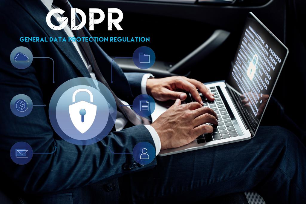 partial view of african american businessman using laptop with gdpr illustration in car - Photo, Image