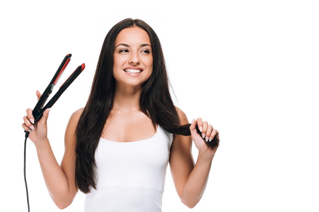 heureuse brune belle femme redresser les cheveux longs brillants avec fer plat isolé sur blanc
 - Photo, image
