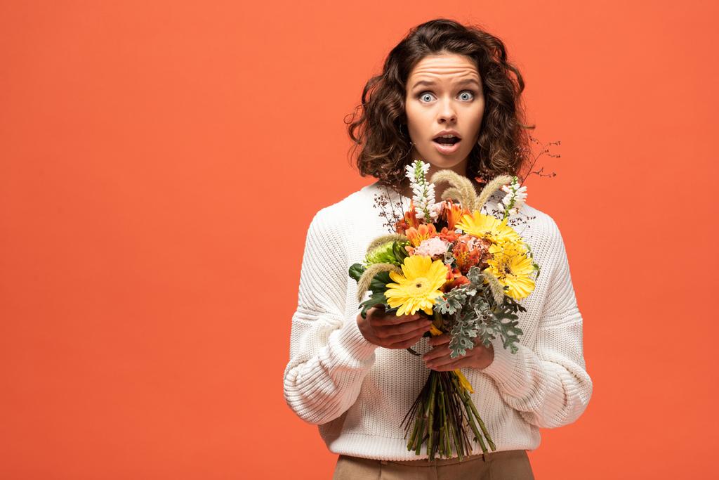 Schockierte Frau im herbstlichen Outfit mit Blumenstrauß in Orange - Foto, Bild