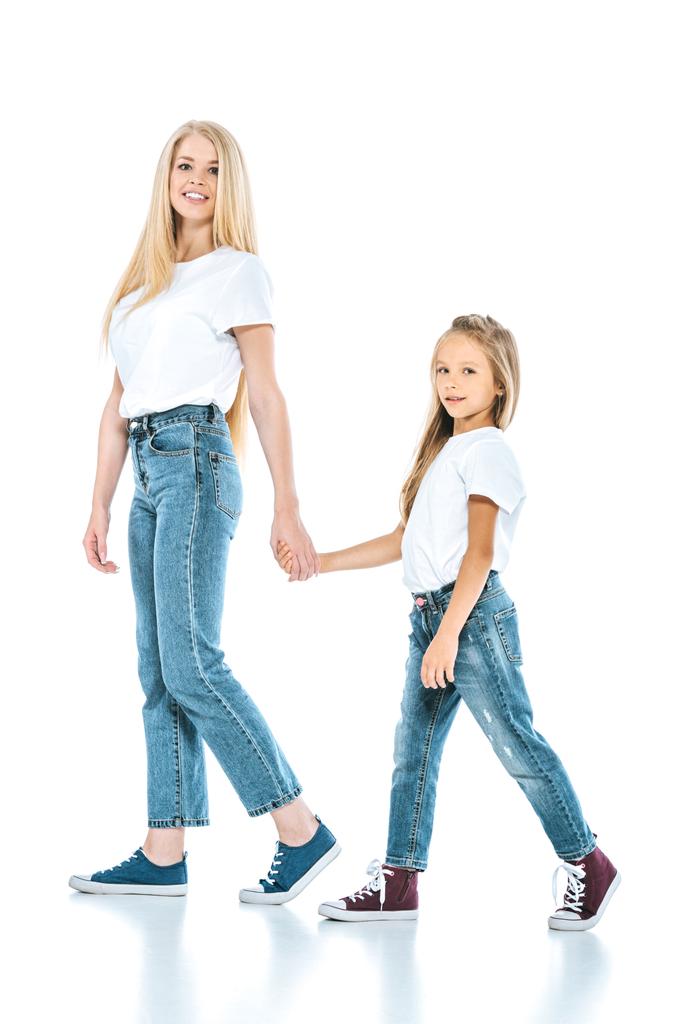 mother and daughter holding hands while walking on white - Photo, Image
