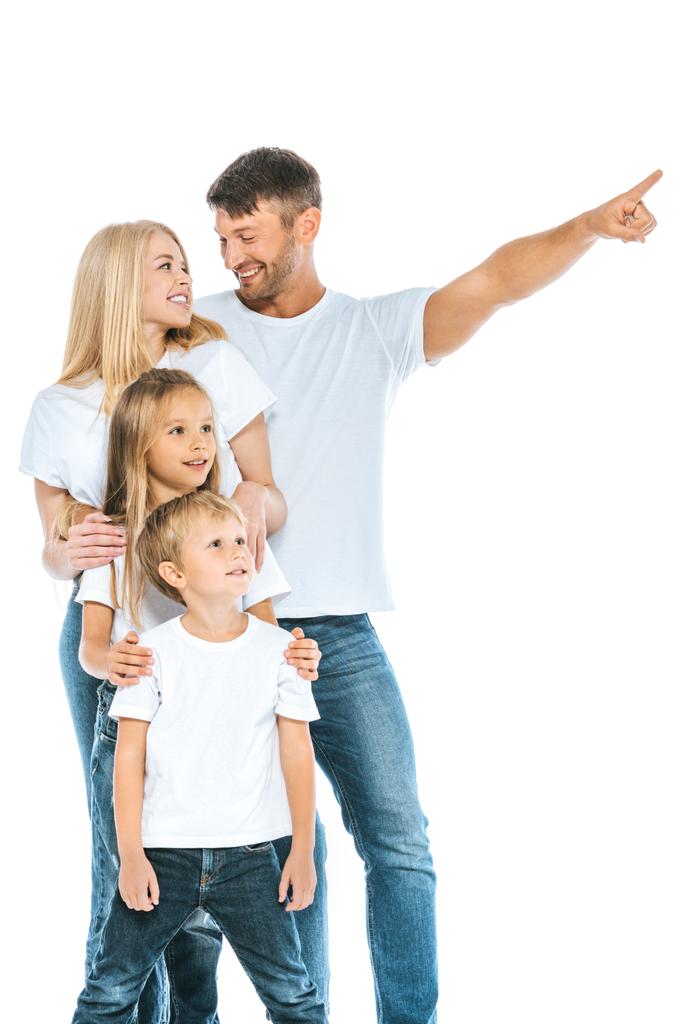 glücklicher Mann schaut Frau an, während er mit dem Finger in der Nähe von Kindern auf weiß zeigt  - Foto, Bild