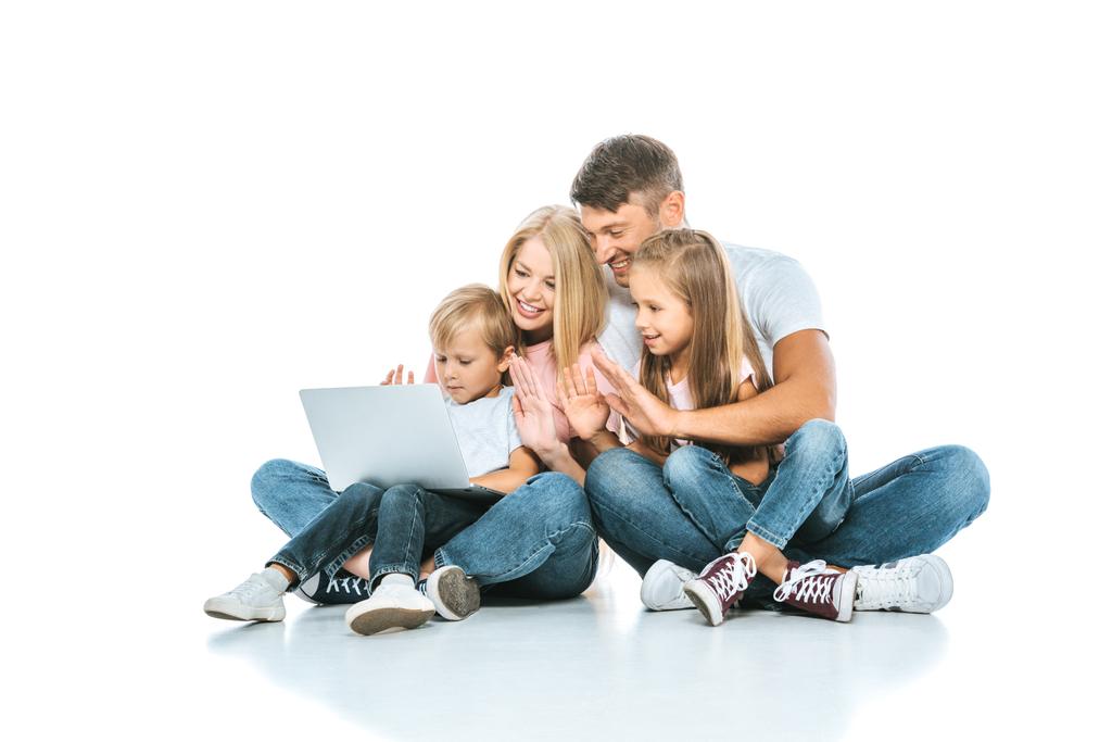 Positive Eltern blicken auf Laptop und winken Kindern in Weiß zu  - Foto, Bild