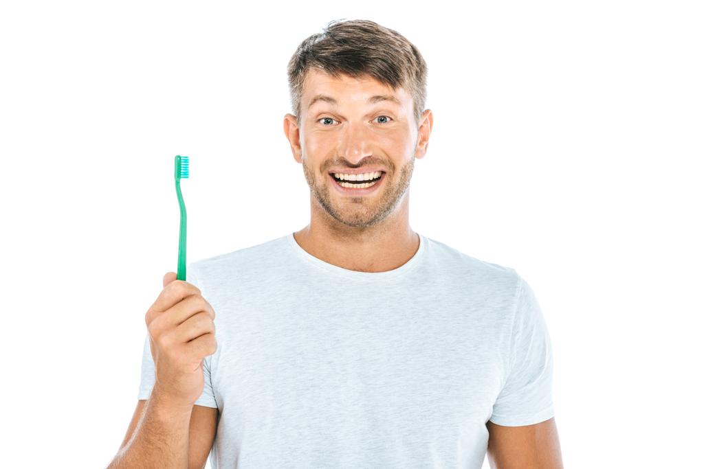 homem alegre segurando escova de dentes enquanto sorrindo isolado no branco
  - Foto, Imagem