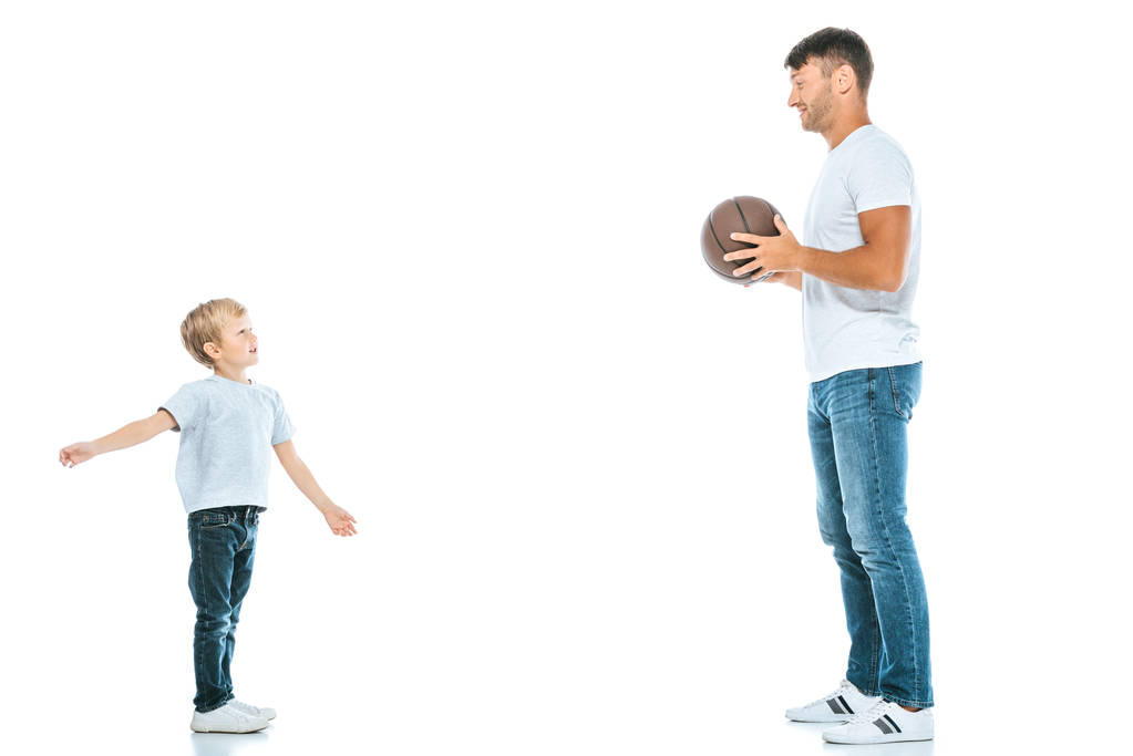side view of happy father holding basketball and looking at son on white  - Photo, Image
