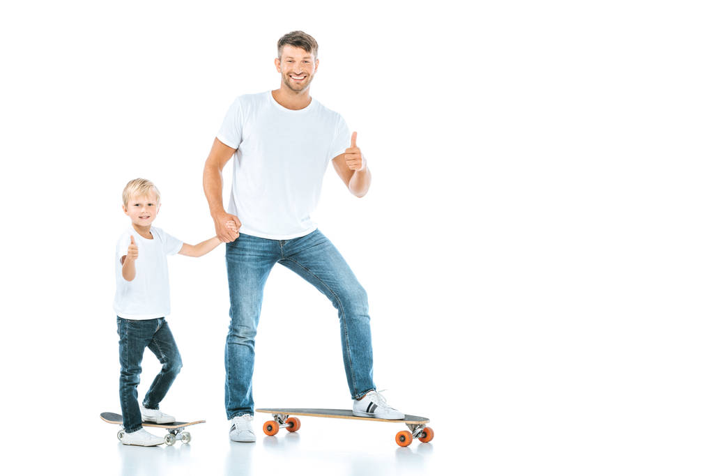 feliz padre e hijo mostrando los pulgares hacia arriba mientras monta peniques aislados en blanco
  - Foto, imagen