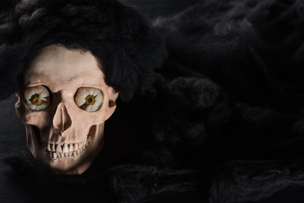 Gruseliger menschlicher Totenkopf auf schwarzem Hintergrund mit Kopierraum, Halloween-Dekoration - Foto, Bild