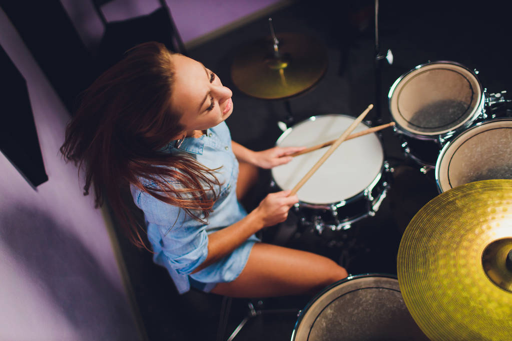 Photograph of a female drummer playing a drum set on stage. - Photo, Image
