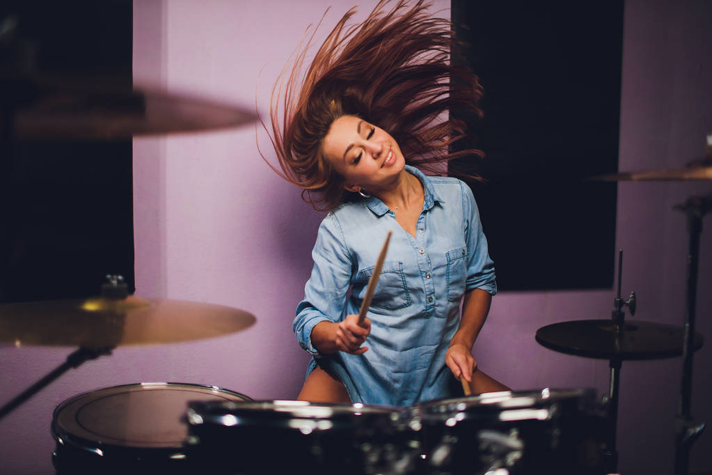Фотография женщины-барабанщика, играющей на барабанах на сцене
. - Фото, изображение