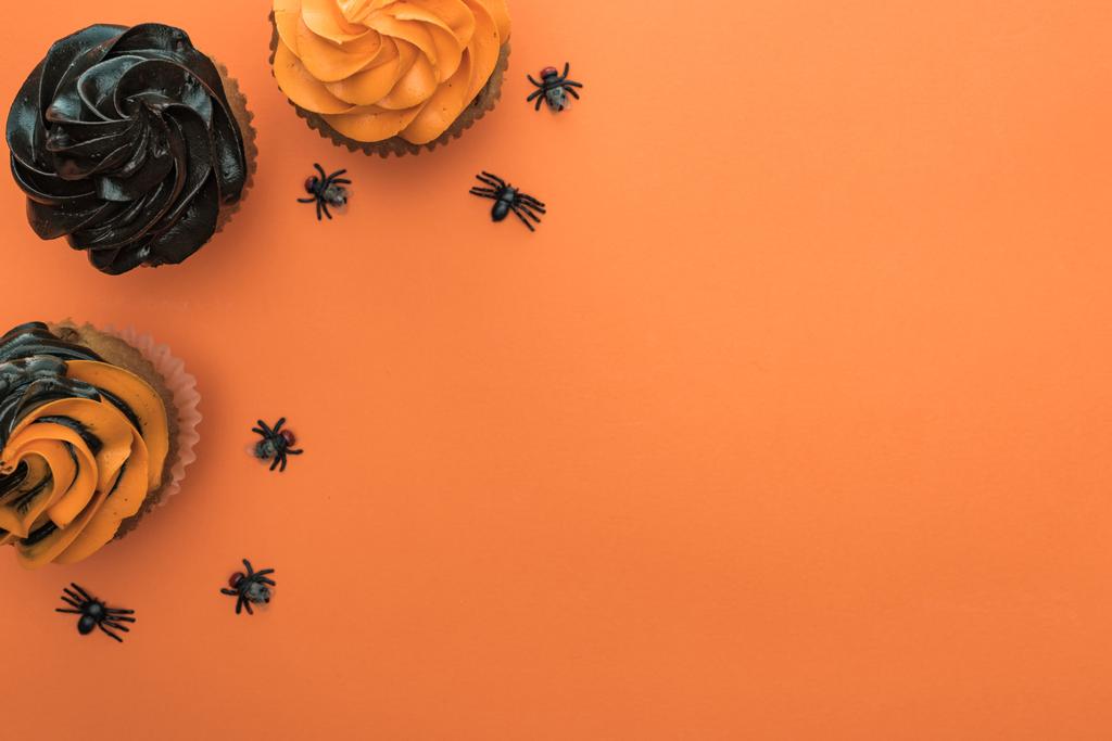 прекрасный вид на вкусные кексы Хэллоуин с пауками на оранжевом фоне с копировальным пространством
 - Фото, изображение
