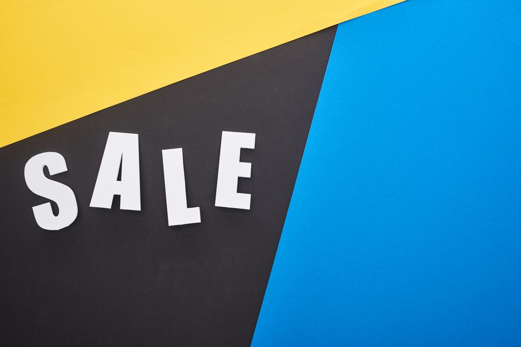 vista superior de la venta de letras sobre fondo azul, amarillo y negro
 - Foto, imagen