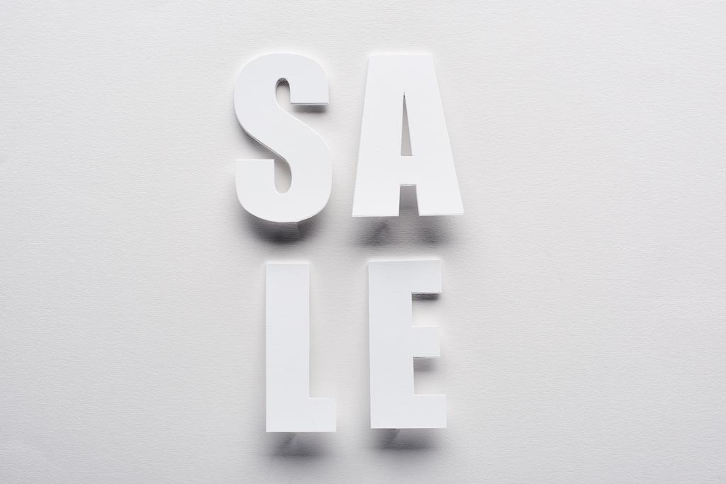 ylhäältä näkymä valkoinen myynti kirjaimet valkoisella taustalla
 - Valokuva, kuva
