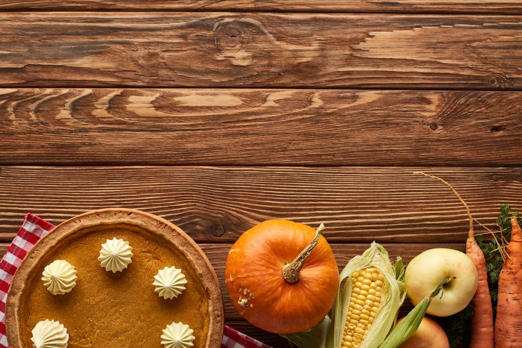 pohled na kostované ubrus s ovocem, zeleninou a dýňovým koláčem na dřevěné ploše s prostorem pro kopírování - Fotografie, Obrázek
