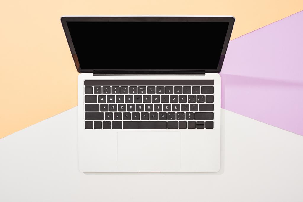 vista dall'alto del computer portatile con schermo bianco su sfondo beige, viola e bianco
 - Foto, immagini