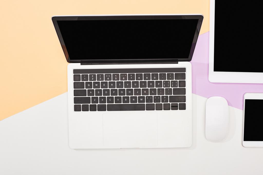 flat lay with laptop, digital tablet, smartphone with blank screen and computer mouse on beige, violet and white background - Photo, Image
