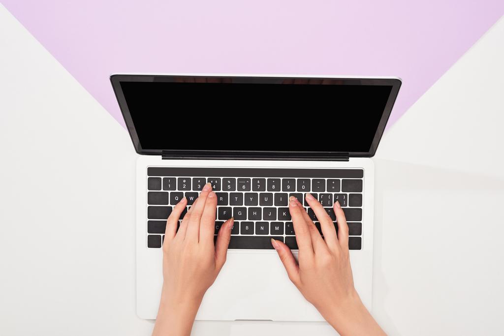 vista recortada de la mujer usando el ordenador portátil sobre fondo violeta y blanco
 - Foto, Imagen