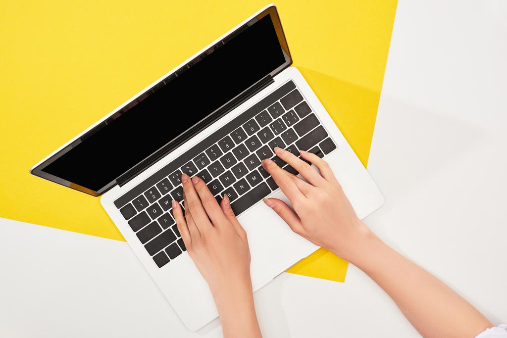 vista recortada de la mujer usando el ordenador portátil sobre fondo amarillo y blanco
 - Foto, Imagen