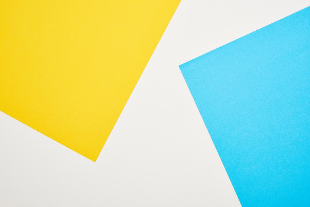 Κορυφαία όψη του γεωμετρικού μπλε, κίτρινου και λευκού φόντου - Φωτογραφία, εικόνα