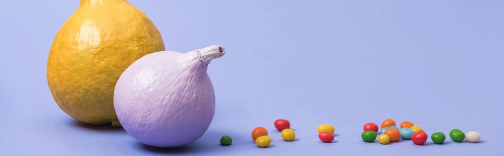 tiro panorâmico de abóboras pintadas com balas no fundo violeta
 - Foto, Imagem