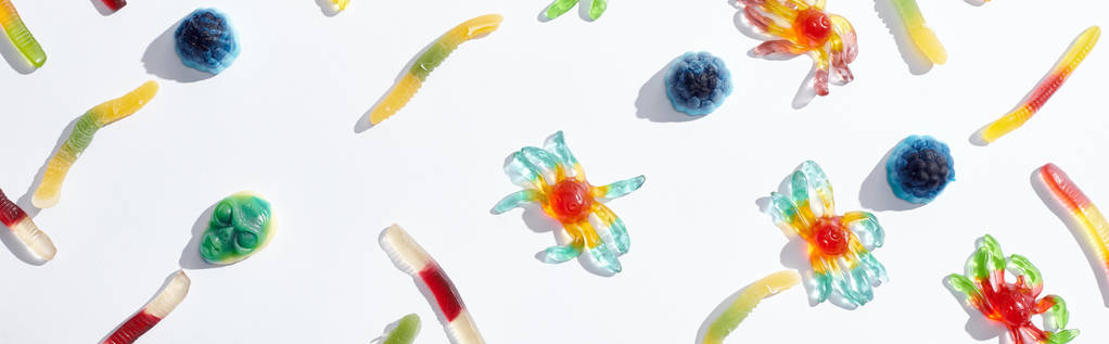 візерунок з барвистими жувальними павуками та хробаками ізольовані на білому, Хеллоуїн ласощі
 - Фото, зображення