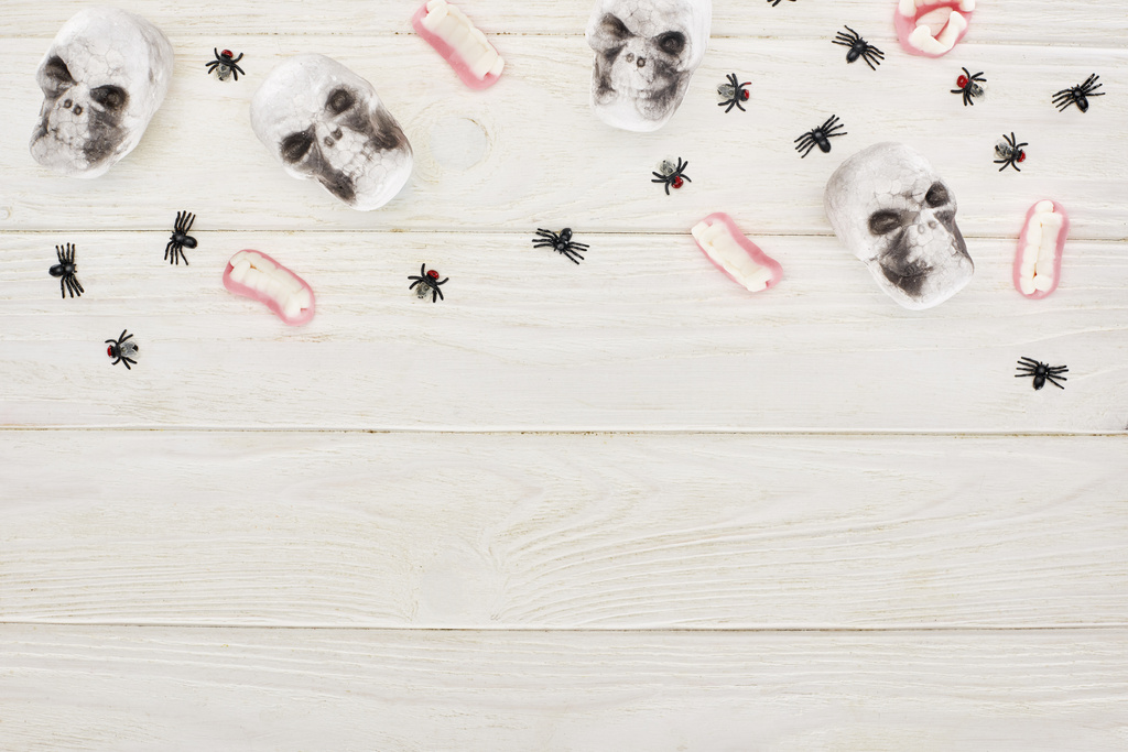 beyaz ahşap masa üzerinde sakızlı dişler, kafatasları ve örümcekler üst görünümü, Cadılar Bayramı tedavi - Fotoğraf, Görsel