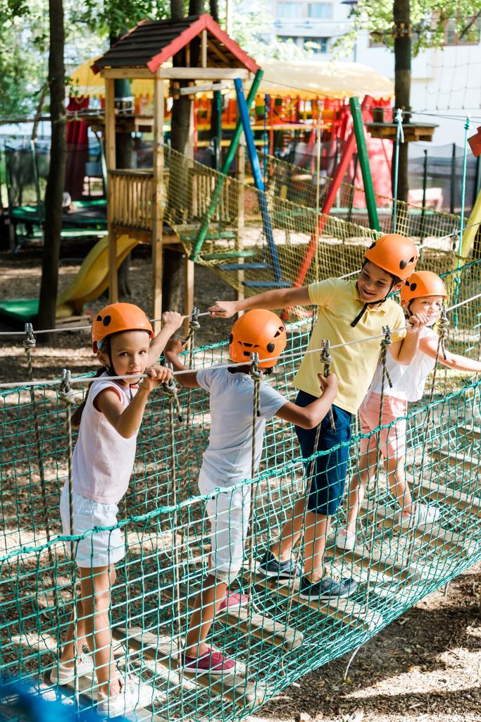 lindos niños multiculturales en cascos cerca de la construcción de madera colorida
  - Foto, Imagen