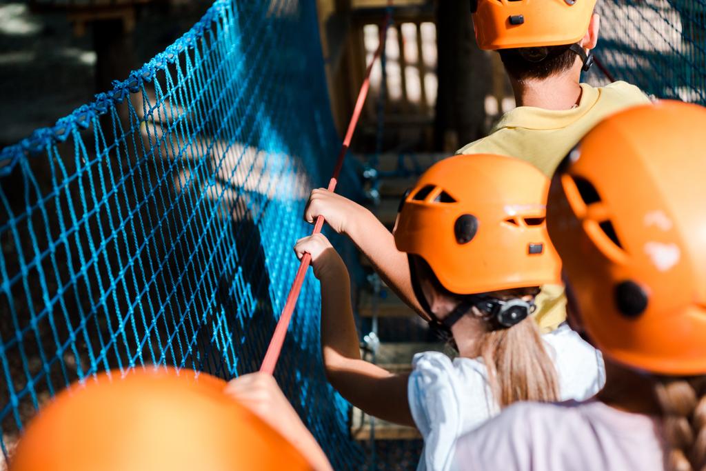 вибірковий фокус дітей в помаранчевих шоломах в парку пригод
  - Фото, зображення