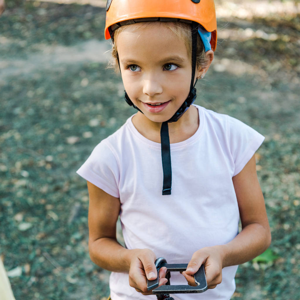 happy kid in helmet holding safety equipment outside - Photo, Image
