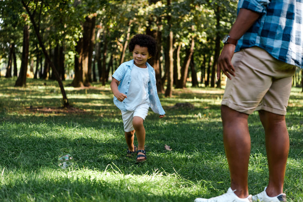 vista ritagliata di uomo africano americano in piedi vicino figlio felice
  - Foto, immagini