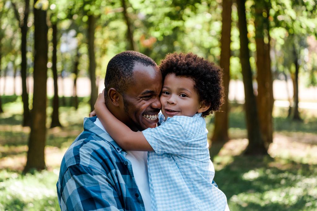 lindo africano americano niño abrazando feliz padre
  - Foto, imagen