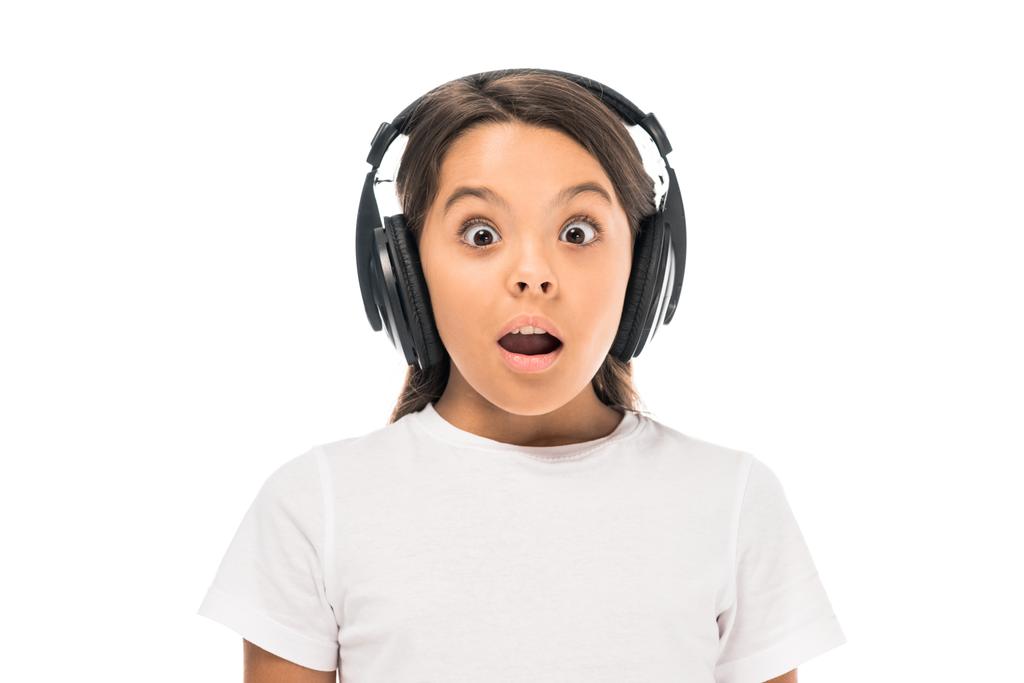 σοκαρισμένο παιδί ακούγοντας μουσική σε ακουστικά που απομονώνονται σε λευκό  - Φωτογραφία, εικόνα