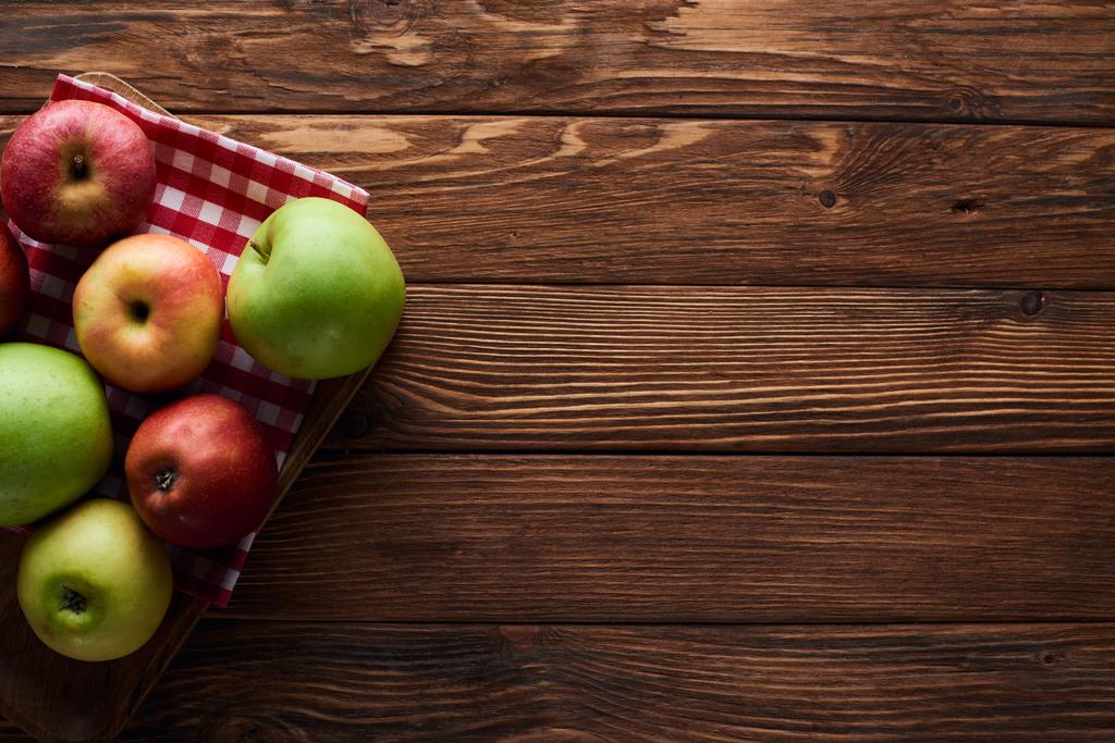 ylhäältä näkymä ruudullinen pöytäliina tuoreita omenoita puupinnalla kopioi tilaa
 - Valokuva, kuva