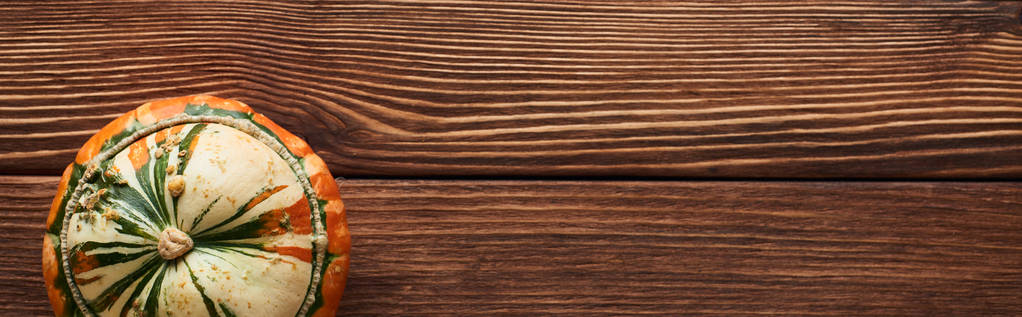panoramiczny strzał małej dojrzałej dyni na brązowej powierzchni drewnianej z kopią przestrzeni - Zdjęcie, obraz
