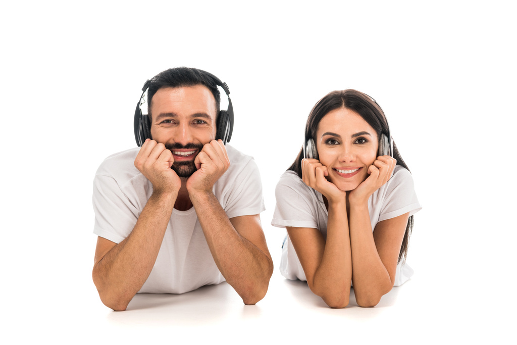 homem feliz e mulher em fones de ouvido olhando para a câmera isolada no branco
  - Foto, Imagem
