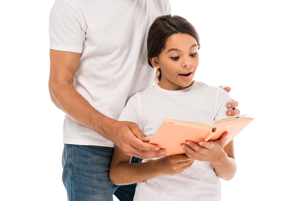 cropped view of father standing near surprised kid reading book isolated on white  - Photo, Image