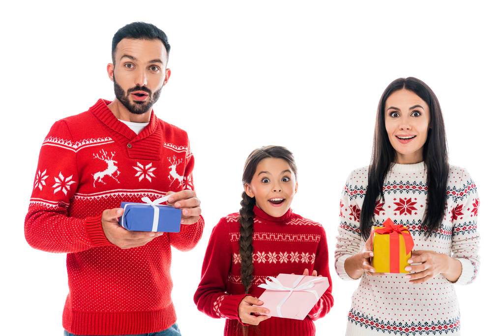 白で隔絶されたプレゼントを持っているセーターを着た興奮した家族  - 写真・画像