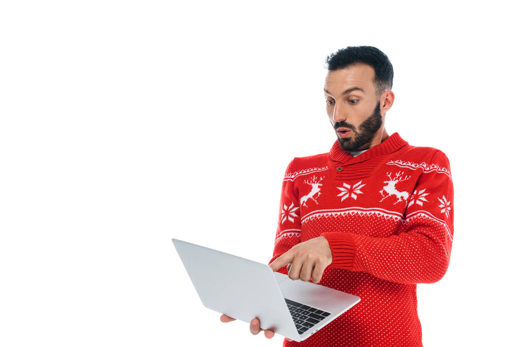 surprised and bearded man in sweater using laptop isolated on white  - 写真・画像