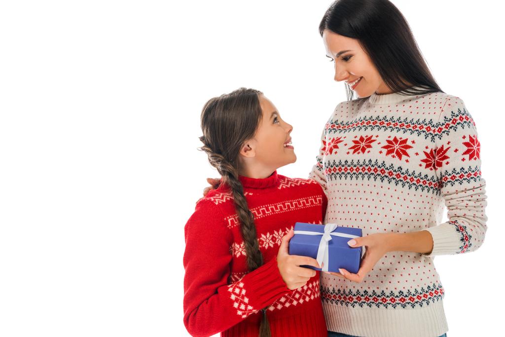 mãe alegre dando caixa de presente azul à filha isolada no branco
  - Foto, Imagem