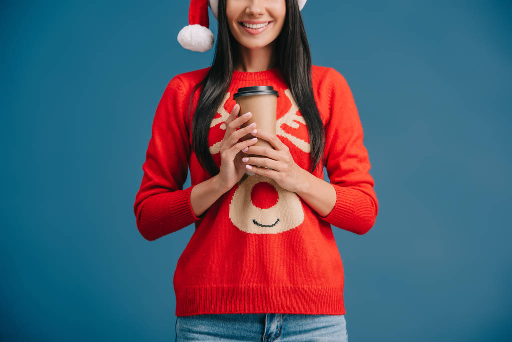 cropped view of happy woman in santa hat holding coffee to go, isolated on blue - Photo, Image