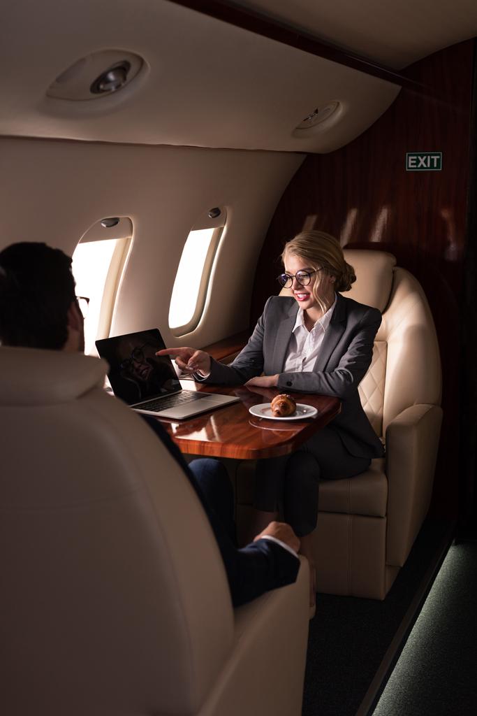 Professionelle Betriebswirte arbeiten mit Laptop im Flugzeug  - Foto, Bild