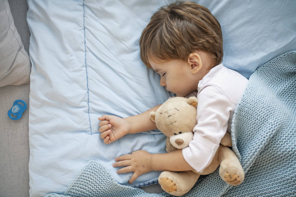 Sevimli uyuyan çocuğun portresi. Uyuyan bebek mutlu ve kaygısız. Ev ve ev kavramı. Mutlu rüyalar, sivrisinek yok, gürültülü ev ve rahat şilteler yok. Rahat çocuklar - Fotoğraf, Görsel