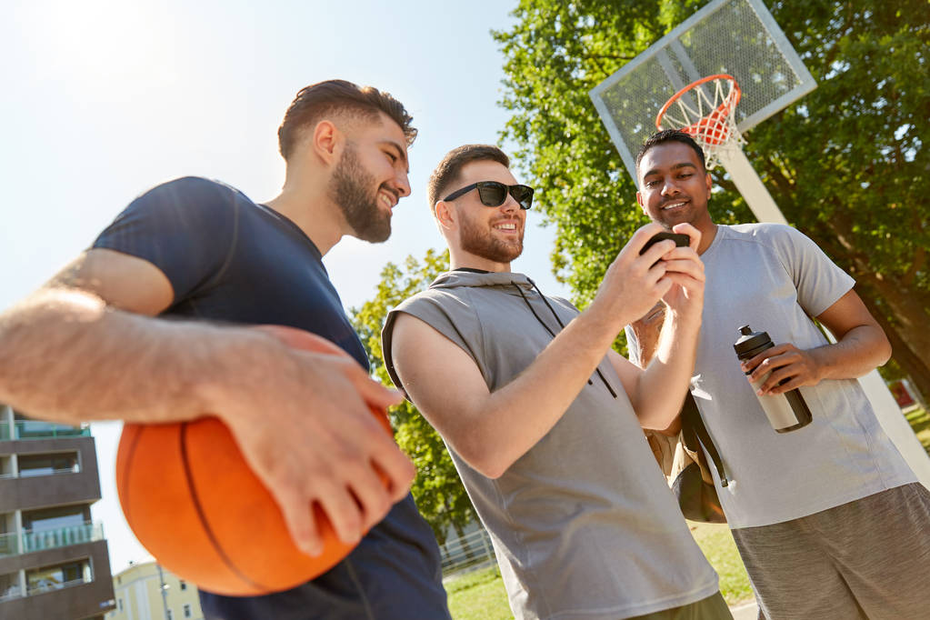 Männer mit Smartphone auf Basketballplatz - Foto, Bild