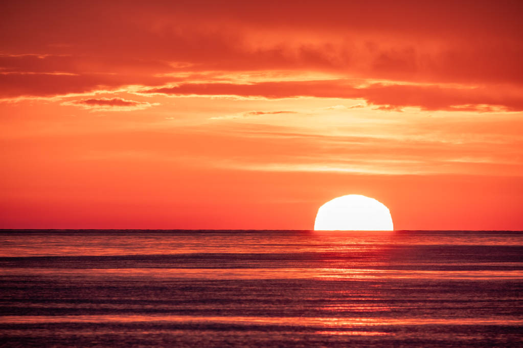 Kaunis punainen ja oranssi auringonlasku meren yllä. Aurinko laskee meren yli.
. - Valokuva, kuva