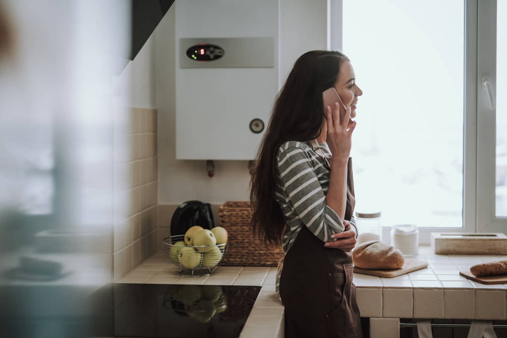 Η εύθυμη γυναίκα κάνει κλήση στην κουζίνα. - Φωτογραφία, εικόνα